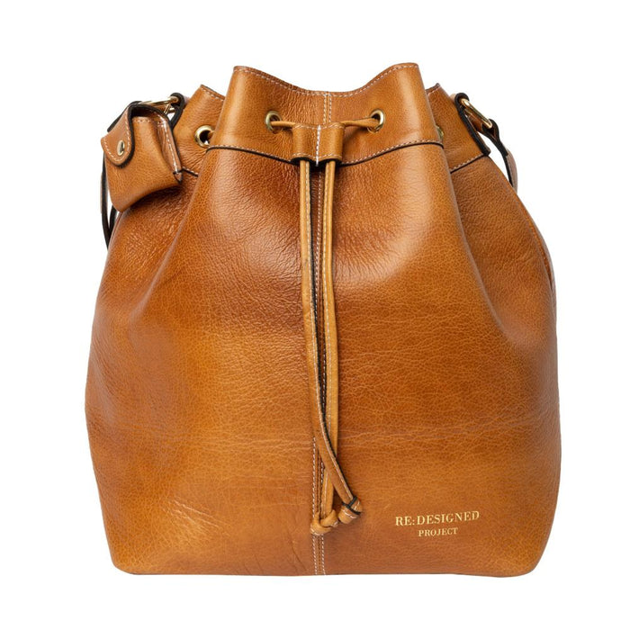 Leather bucket bag in burned tan with gold accents, ideal knitting bag with adjustable strap and pockets.