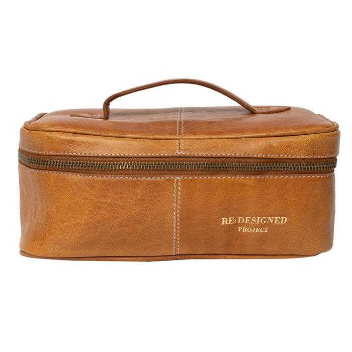 Knitting bag in burned tan leather with zippered compartment and handle.