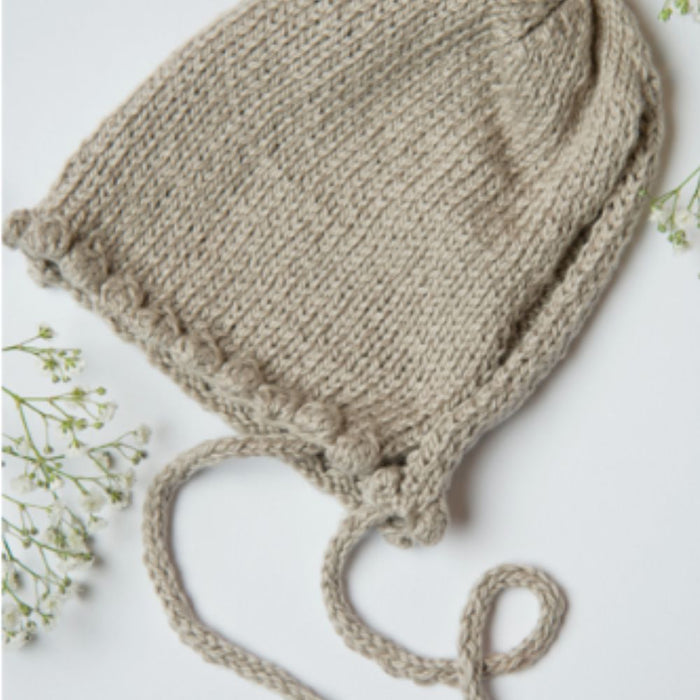 Noe Bobble Bonnet knitting pattern featuring textured bobbles, suitable for babies aged 0-24 months.