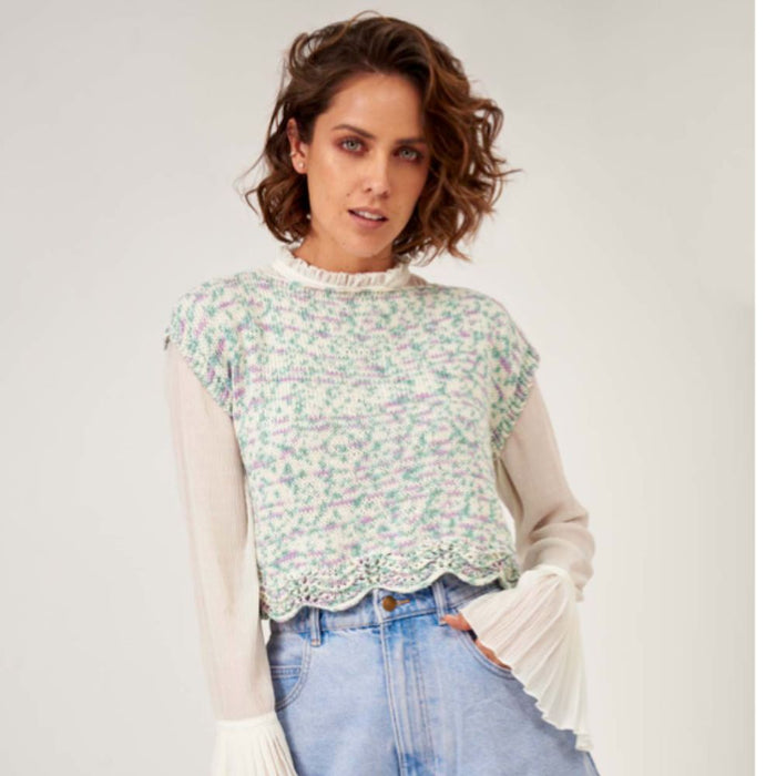 Woman wearing a knitted Zoe Romper Set sweater with lace pattern.