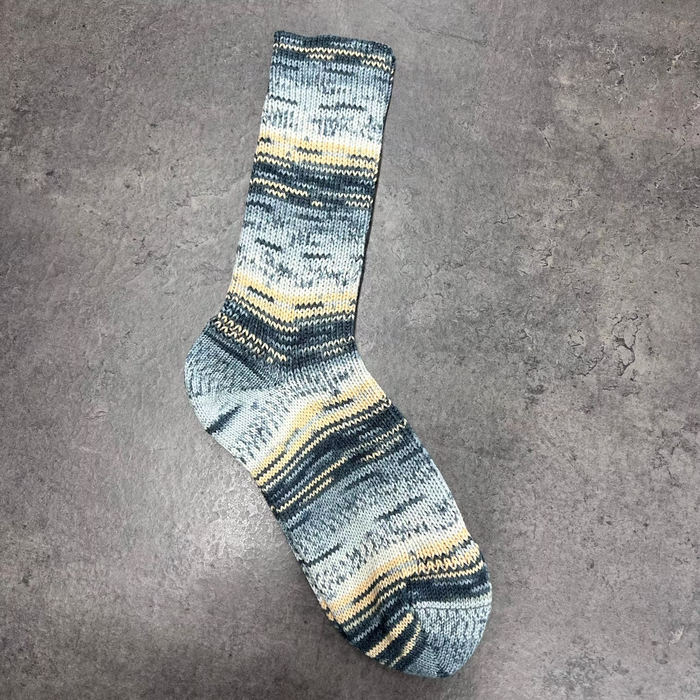Stylish blue and yellow patterned sock on gray background.
