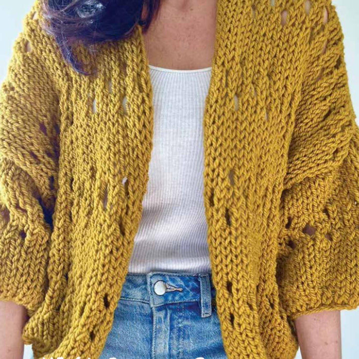 Emma Cardigan featuring eyelet pattern and three-quarter sleeves in mustard yellow, crafted from chunky yarn.