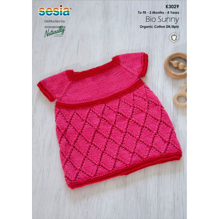 Summer Lace Dress for Girls knitting pattern in pink lace design, suitable for 3 months to 4 years, shown with circular needles.