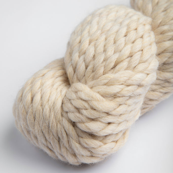 Amano Mamacha Super Chunky yarn in a soft cream color, featuring a luxurious blend of baby alpaca and merino wool for warmth and comfort.
