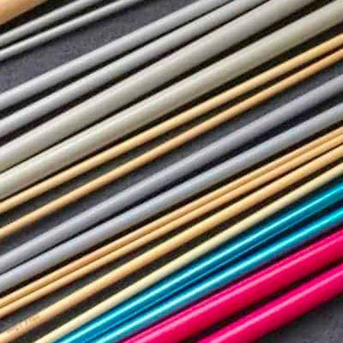 Various different types of knitting needles including bamboo, metal, plastic, wooden, and carbon fiber on a white background