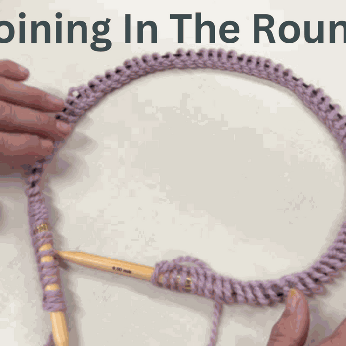 Hands joining knitting stitches in the round on circular needles