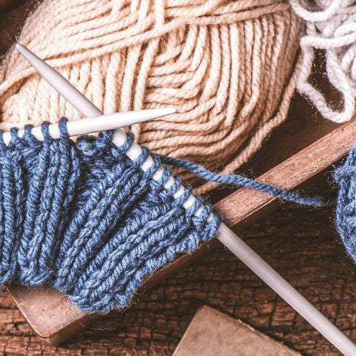 Beginner knitter fixing common knitting mistakes with yarn and needles