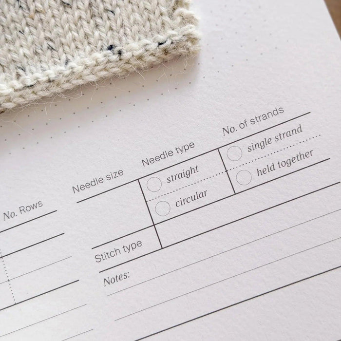 Knit Notes Folder A4 record sheet with minimalist design and spaces for knitting project details, pre-punched holes for swatches and binder, printed on premium card.