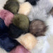 Faux fur pom poms with snap fasteners in assorted colors, 12cm diameter, perfect for beanies and accessories.