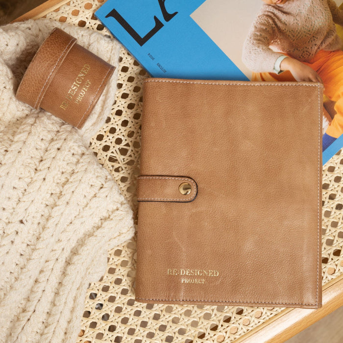 Taupe leather Project 14 interchangeable needle case with organized pockets on a knitting background.