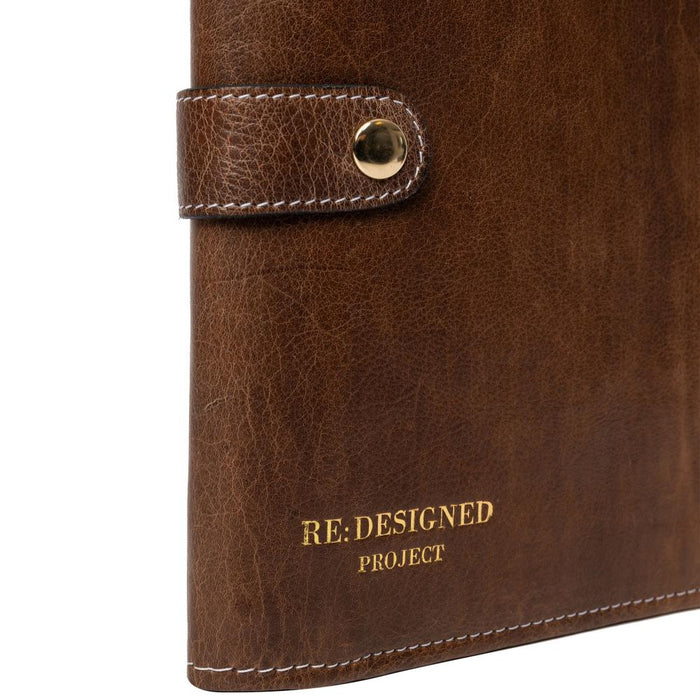 Knitting needle case in woodsmoke leather with snap closure for organizing tools.