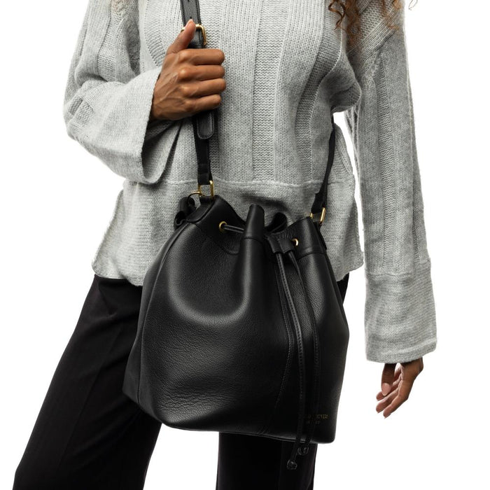 Black and gold genuine leather bucket bag with adjustable strap, featuring inside zip pocket, open pockets, and leather drawstring, ideal for knitting projects.