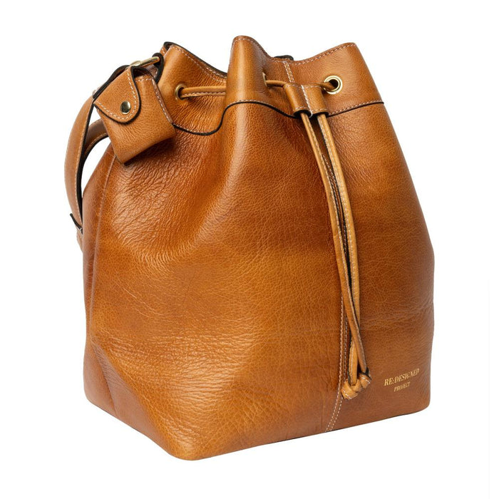 Genuine leather knitting bucket bag in burned tan and gold with adjustable strap and drawstring.