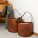 Small bucket bag in walnut leather, designed for style and practicality, featuring a sturdy structure and comfortable handle, perfect for knitters.
