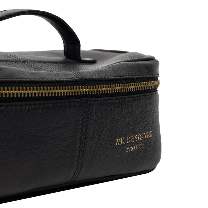 Black leather knitting project bag with zippered compartment and handle.
