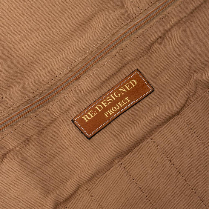 Knitting bag interior with tan fabric and zipper pocket, labeled "Re:Designed Project."