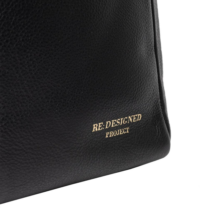 Black leather knitting bag with spacious compartments and metal zipper closure.