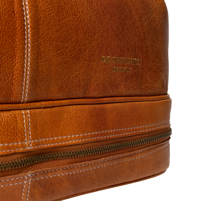 Burned tan leather knitting project bag with circular needle compartment.