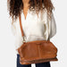 Knitting bag in walnut leather with shoulder strap and multiple compartments.