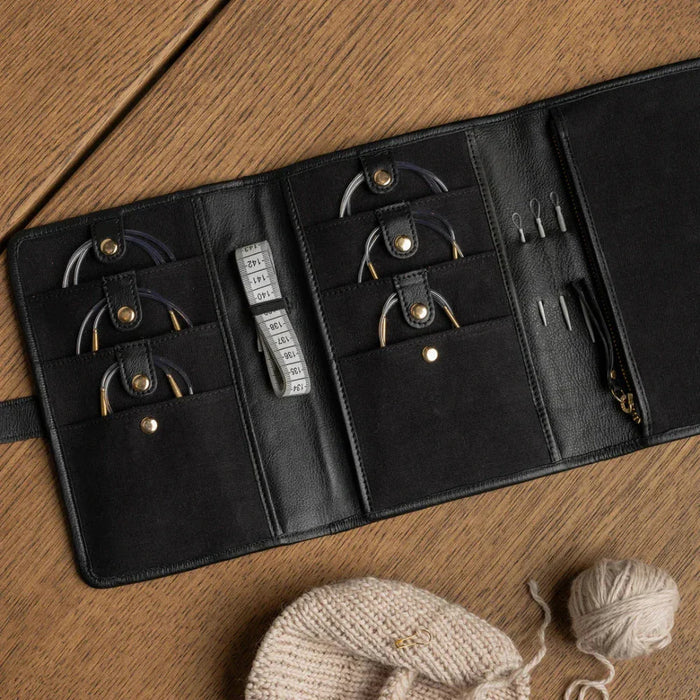 Black and gold Project 7 circular needle knitting case with pockets and zippered sections, handcrafted leather design.