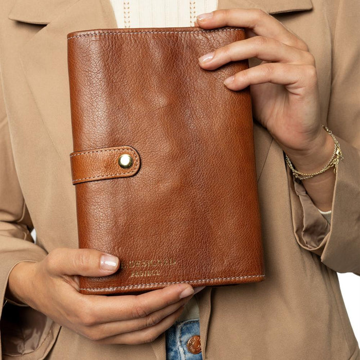 Knitting bag for circular needles in walnut gold leather with pockets and snap closure.