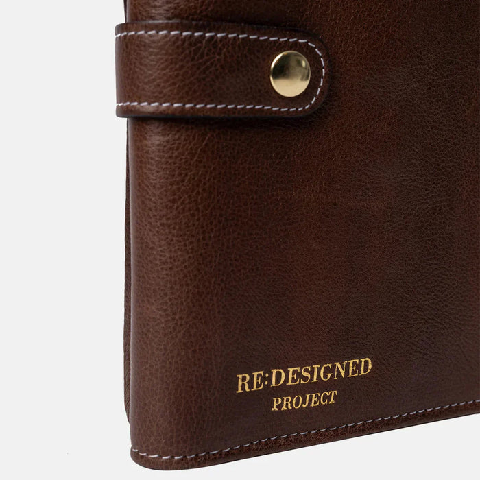 Circular needle knitting case in woodsmoke leather with snap closure and multiple pockets.