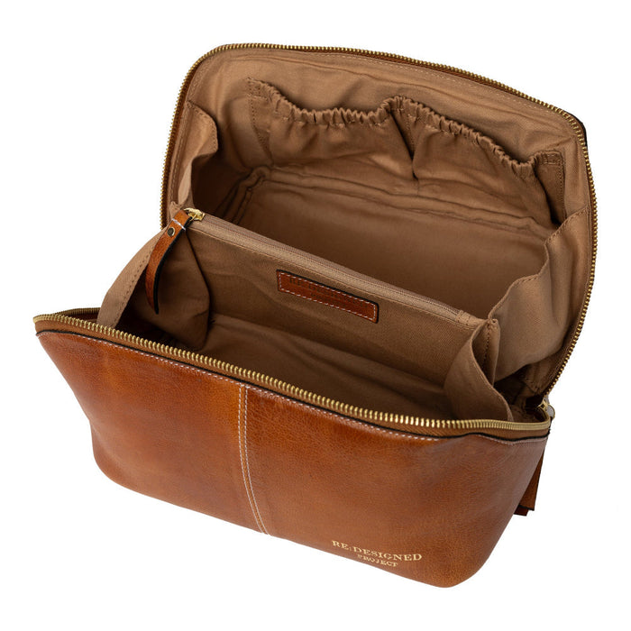 Knitting bag in burned tan and gold leather with multiple compartments.