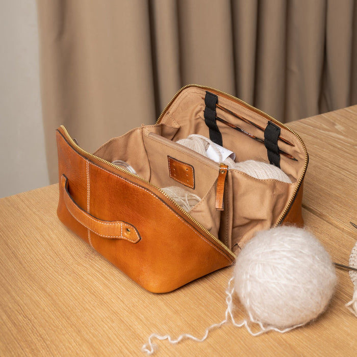 Knitting bag made of premium burned tan leather with organized compartments for tools and yarn.