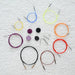 Set of colorful circular knitting needles and accessories on a textured white background
