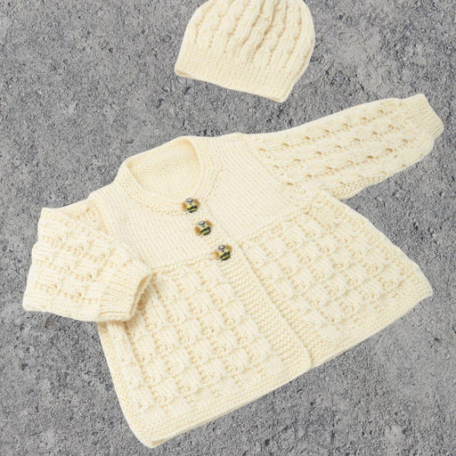 Textured baby jacket and hat set in cream 4ply yarn with lace pattern and garter stitch trims.