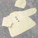 Textured baby jacket and hat set in cream 4ply yarn with lace pattern and garter stitch trims.