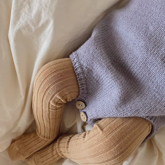 Knitted romper suit from Anker's Suit Knitting Pattern by PetiteKnit.