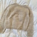 Anker's Sweater adult knitting pattern by PetiteKnit, showcasing the ribbed yoke design and stockinette body on a flat surface.