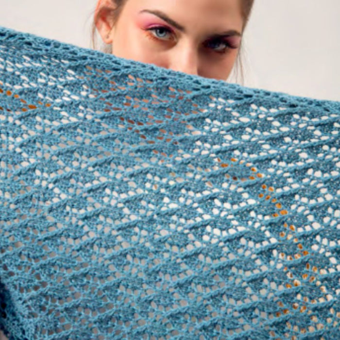 Intermediate-level Aurora stole knitting pattern with chevron and arrowhead lace designs in blue yarn.
