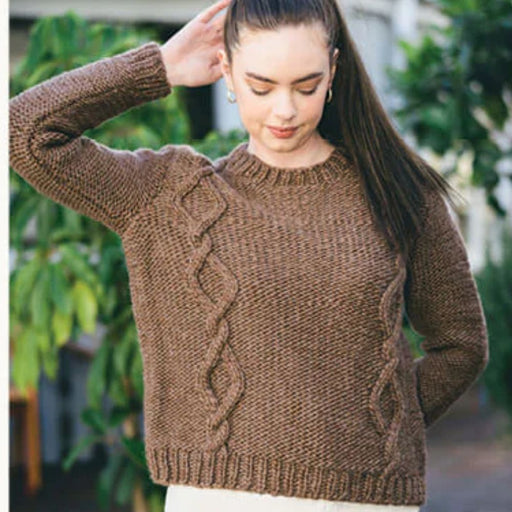 Woman wearing a natural brown cable sweater made with Crucci Natural Wonder wool, showcasing knitting pattern CRU2114 for intermediate knitters.