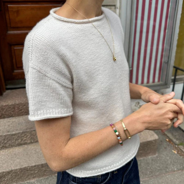 Cloud Tee knitted in white yarn, displayed on a model outdoors, showcasing short sleeves and a smooth stockinette stitch pattern; focus on petite knits design.