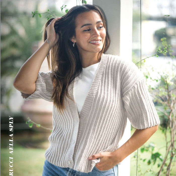 Woman wearing a ribbed Deep V Cardigan made with Crucci Aella 8ply yarn; stylish knitting pattern design.