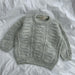 Esther Sweater Junior knitting pattern, textured design on flat surface.