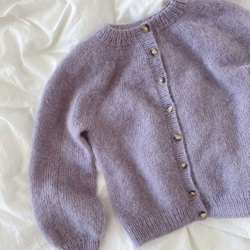Novice Cardigan Junior Mohair Edition knitting pattern by PetiteKnit, featuring a lilac stockinette cardigan with round yoke and ribbed edges.