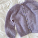 Novice Cardigan Junior Mohair Edition knitting pattern by PetiteKnit, featuring a lilac stockinette cardigan with round yoke and ribbed edges.