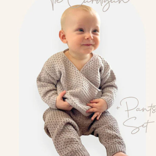 Baby wearing knitted tie cardigan and pants set; knitting pattern for Crucci Luxury Merino Crepe 4ply, sizes 0-12 months.