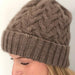 Cabled beanie with intricate design, knitted in Possum Fusion DK yarn for warmth and style.