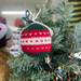 Christmas bauble knitted from DK/8 Ply yarn using festive pattern hanging on tree.
