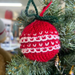 Knitted Christmas bauble hanging on tree, made from DK yarn.