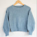Cropped sweater knitting pattern with textured stitch, long sleeves, and ribbed crew neckline.