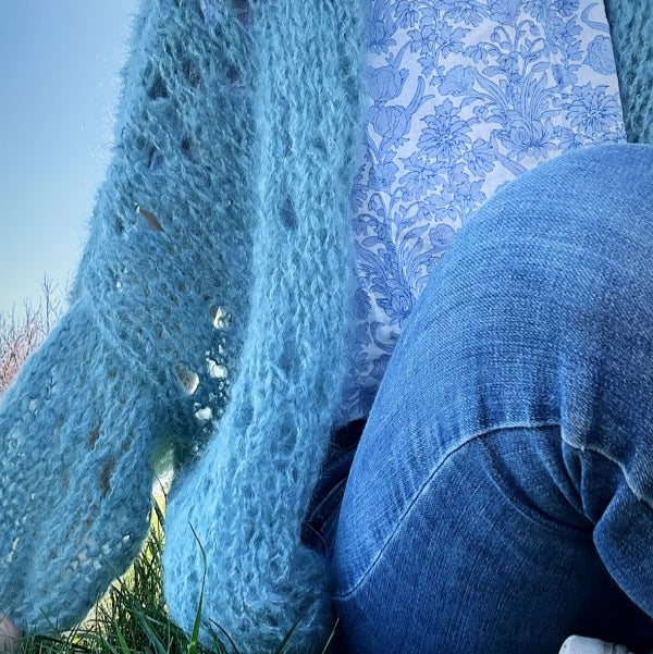 Cozy blue eyelet knit cardigan with three-quarter sleeves and relaxed fit.