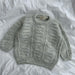 Esther Sweater Junior knitting pattern, textured design on flat surface.