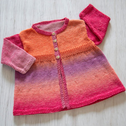 Knitted little girls' jacket in vibrant colors with buttoned front, moss stitch edges, and seamless design.