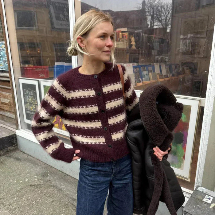 Woman wearing a striped cardigan following the PetiteKnit key cardigan pattern.