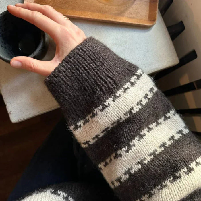 Close-up of sleeve detail in two-color striped pattern from the Key Sweater knitting pattern by PetiteKnit.